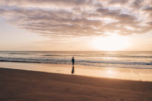 Lonely person walking on empty seashore
