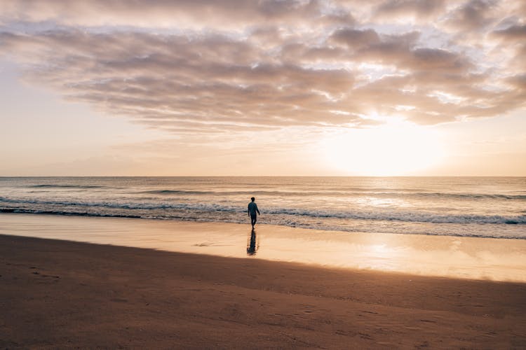 Lonely Person Walking On Empty Seashore