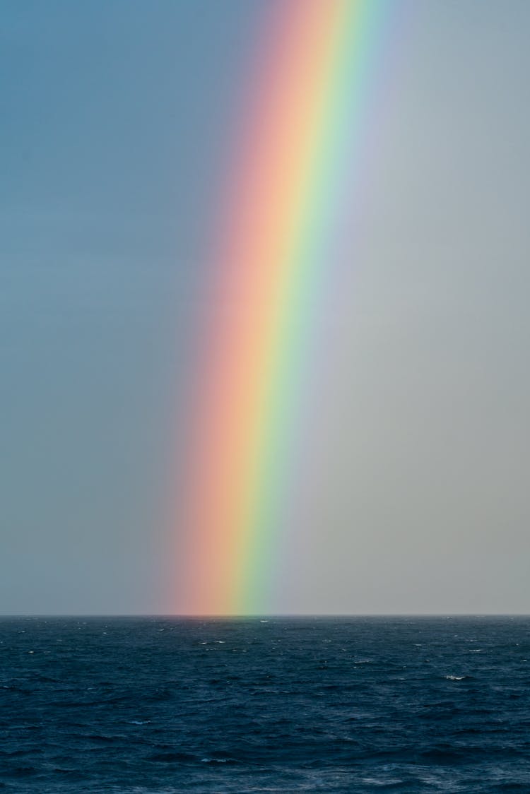 Sky With Rainbow Over Rippling Blue Ocean