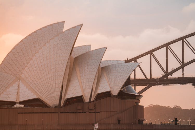 Contemporary Stylish Building And Arch Bridge Against Pink Sundown Sky