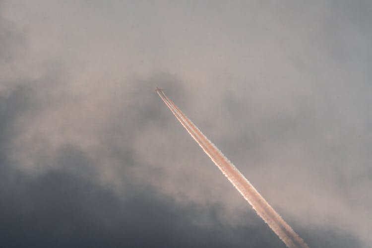 Airplane Flying In Cloudy Evening Sky