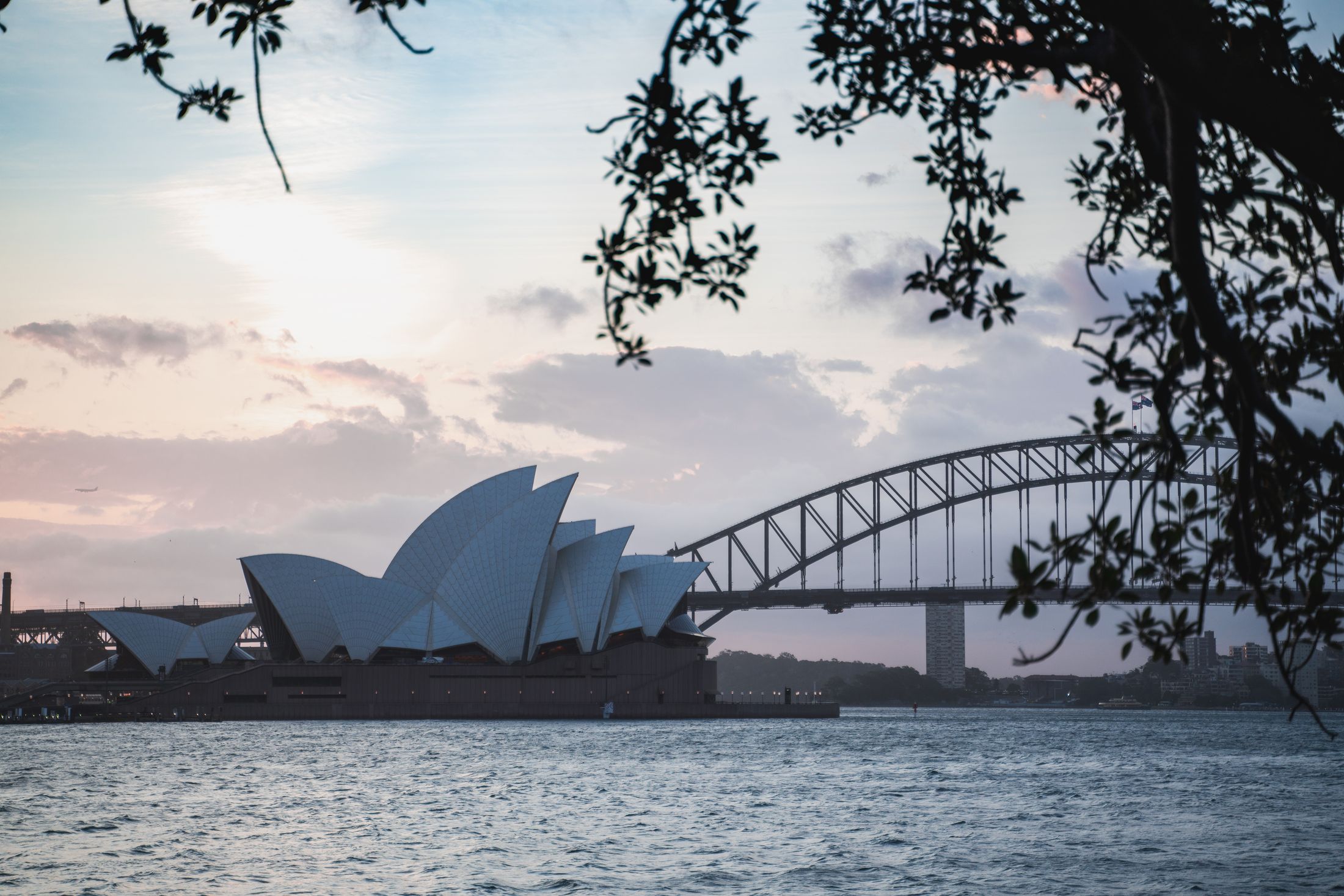 Sydney Opera House and Harbour Bridge at twilight, the water gone to glass
