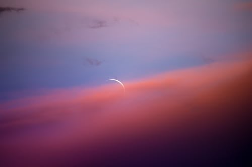 Free Crescent Moon in Orange Clouds in the Blue Sky Stock Photo
