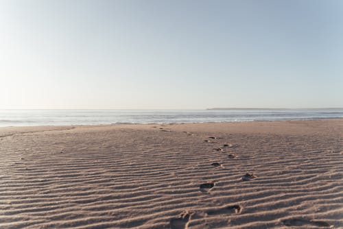 Plage De Sable Avec Des Empreintes Humaines Par Temps Clair