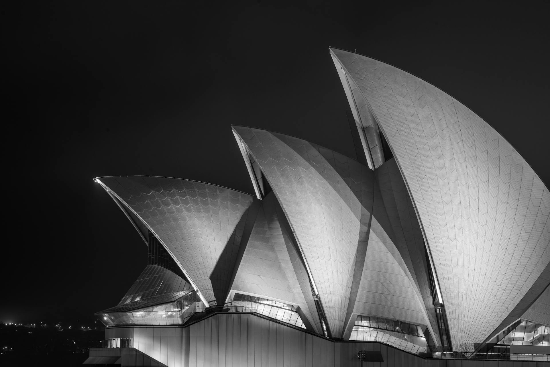 Contemporary exterior design of Sydney Opera House with white concrete panels forming shells at dark night