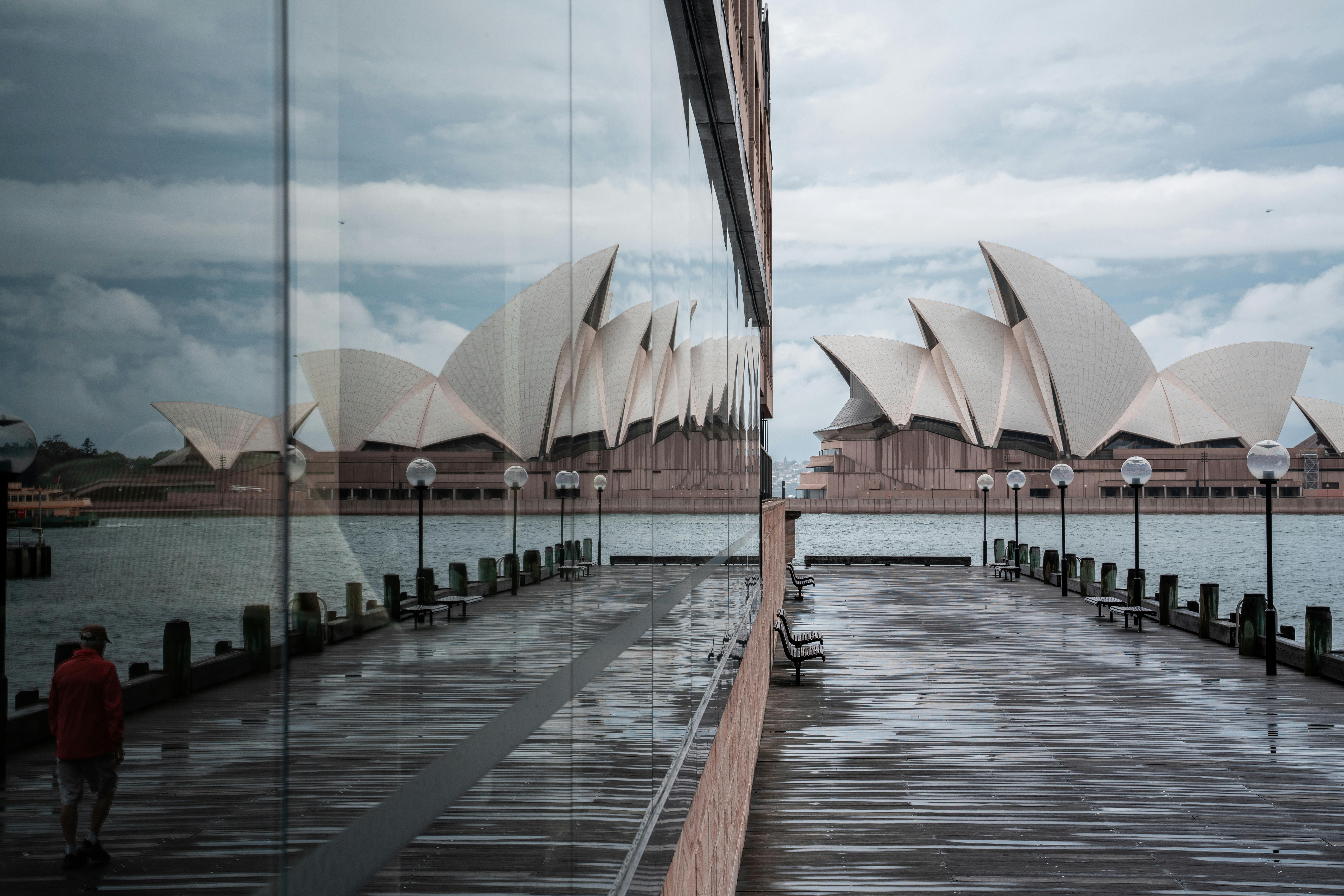 majestic sydney opera house reflecting in neighbor building glass wall