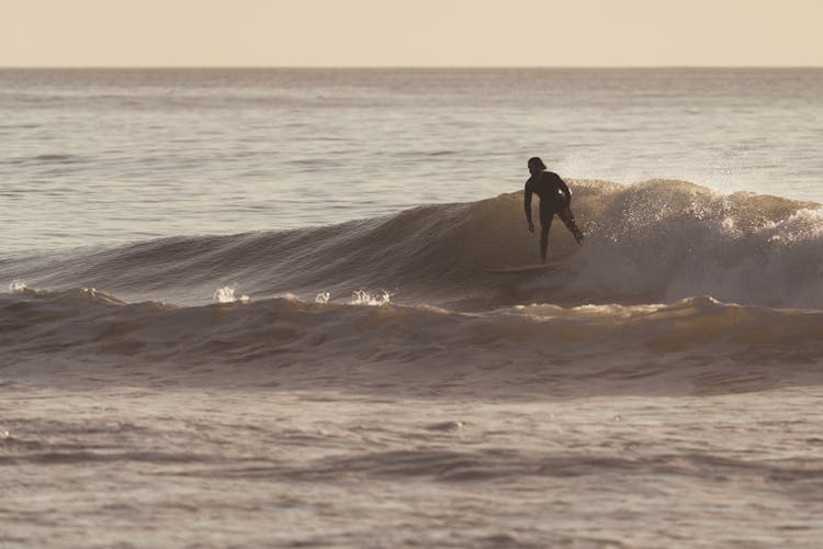 Man Surfing On Wave Of Powerful Ocean