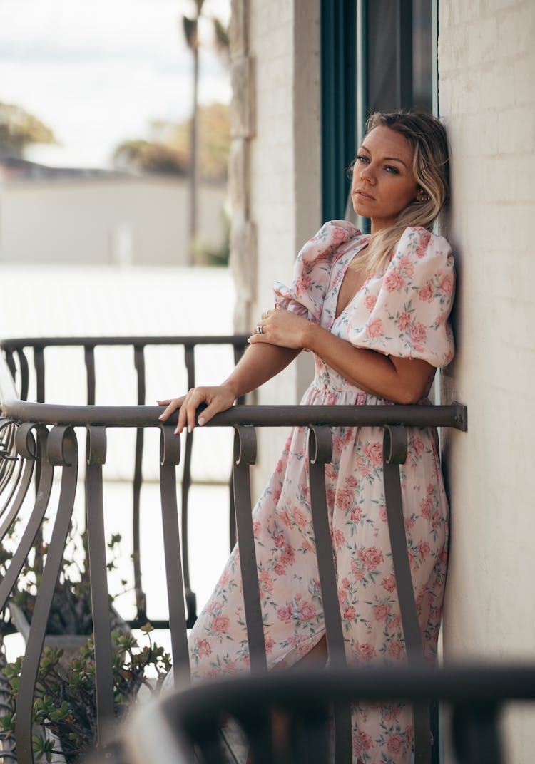 Woman In Delicate Dress In Balcony With Metal Railing