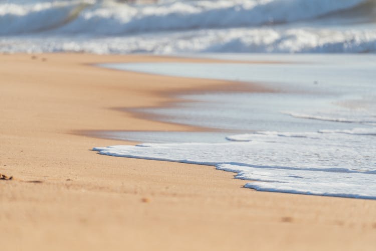 Wave Of Ocean Washing Empty Sandy Beach