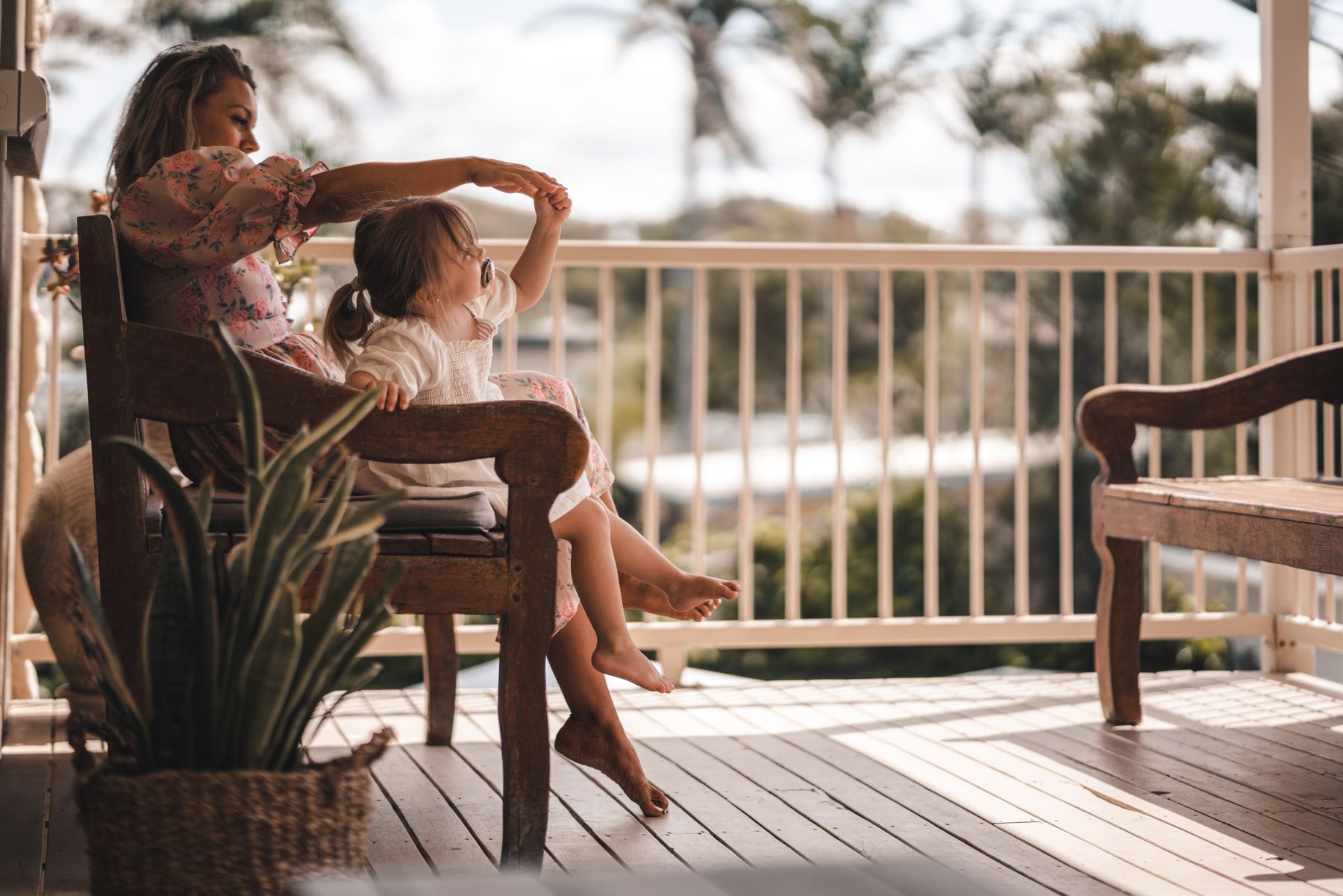Happy mother playing with her cute daughter in a bright living room