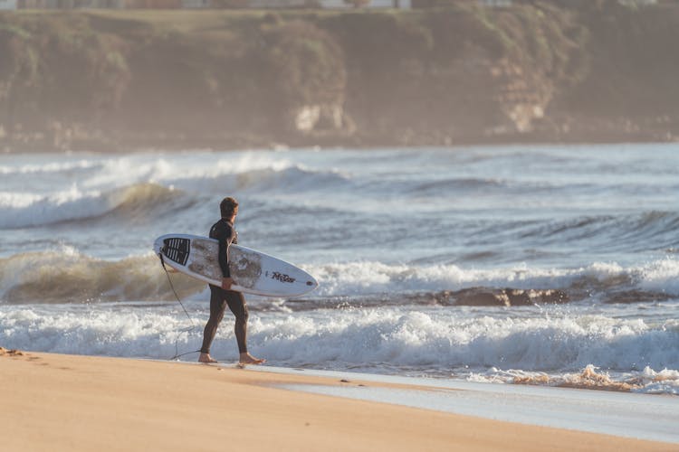 Man Preparing For Surfing In Wavy Ocean