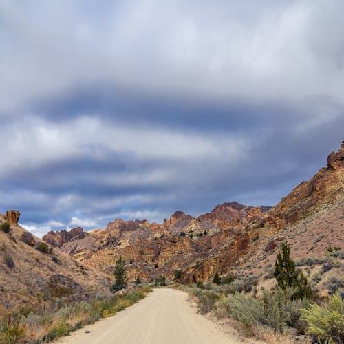 Empty sandy roadway in rocky terrain