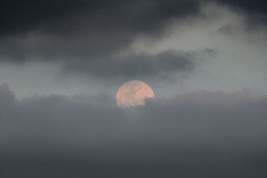 乌云中浮现的满月，为夜空增添了几分喜怒无常的神秘感
