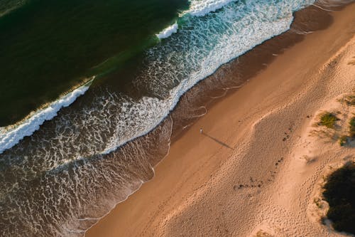 Sandy beach with waving sea