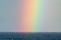 在宁静的海洋地平线上延伸的五颜六色的彩虹的壮丽景色