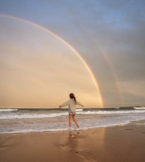 海灘的匿名婦女與彩虹