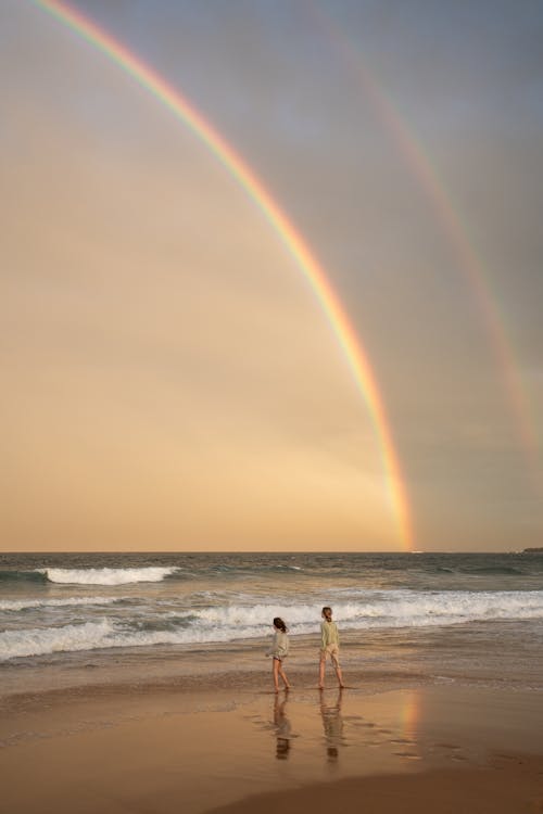 бесплатная 2 человека, стоящие на пляже Стоковое фото