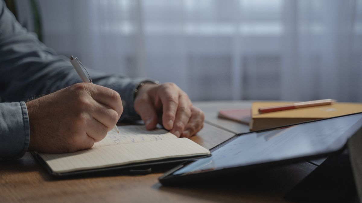 ノートとタブレットを並べて書き出している手元のイメージ