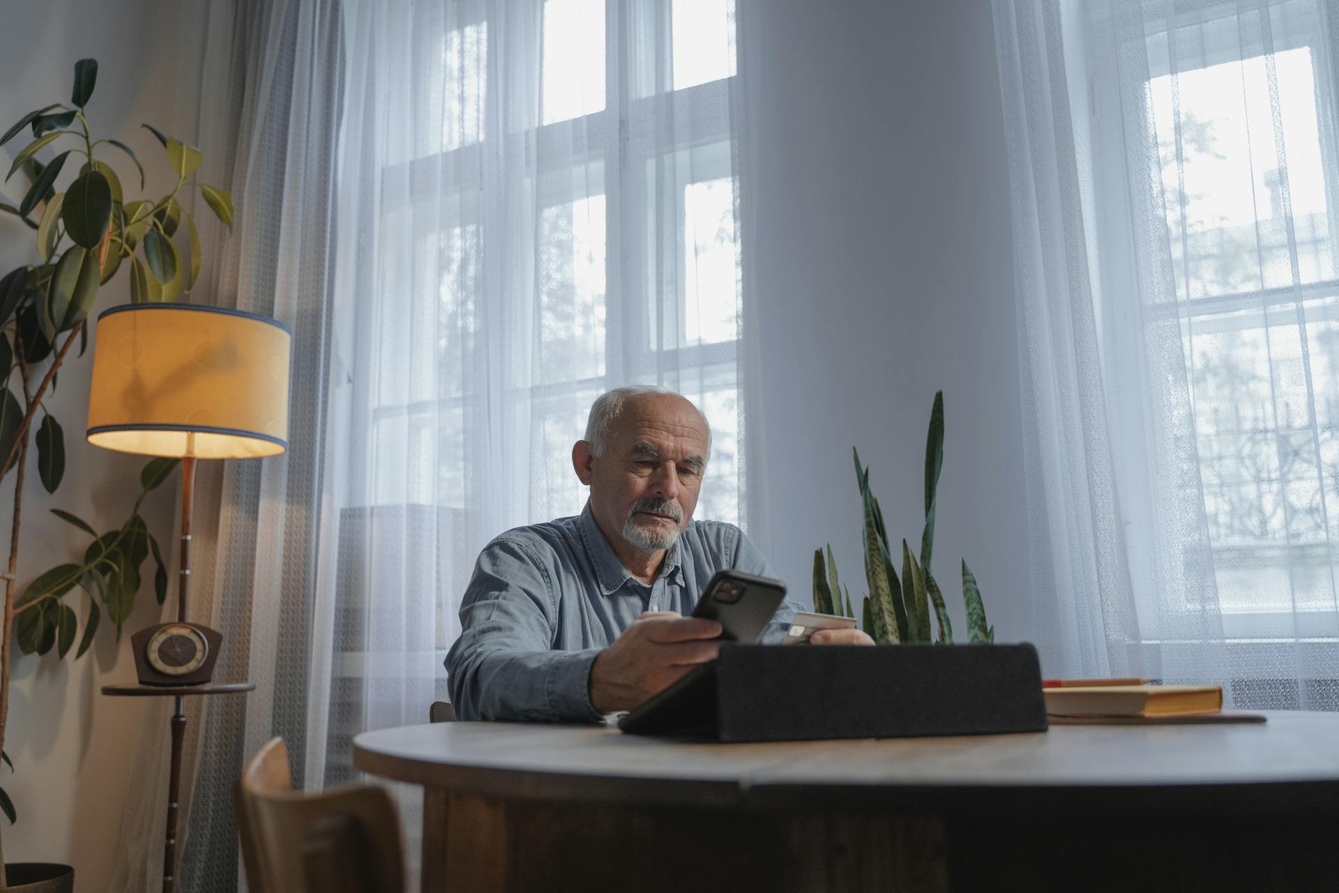 A Low Angle Shot of an Elderly Man Using His Mobile Phone