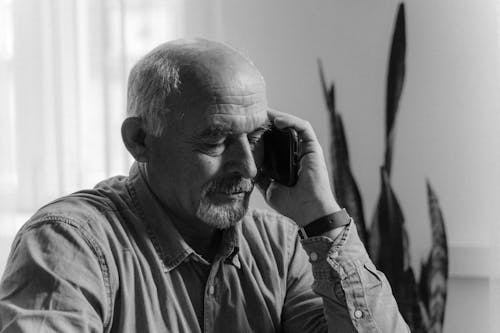 A Man Talking on the Black Smartphone