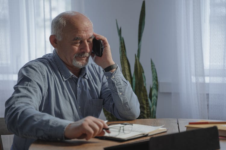 An Elderly Man Talking On The Phone