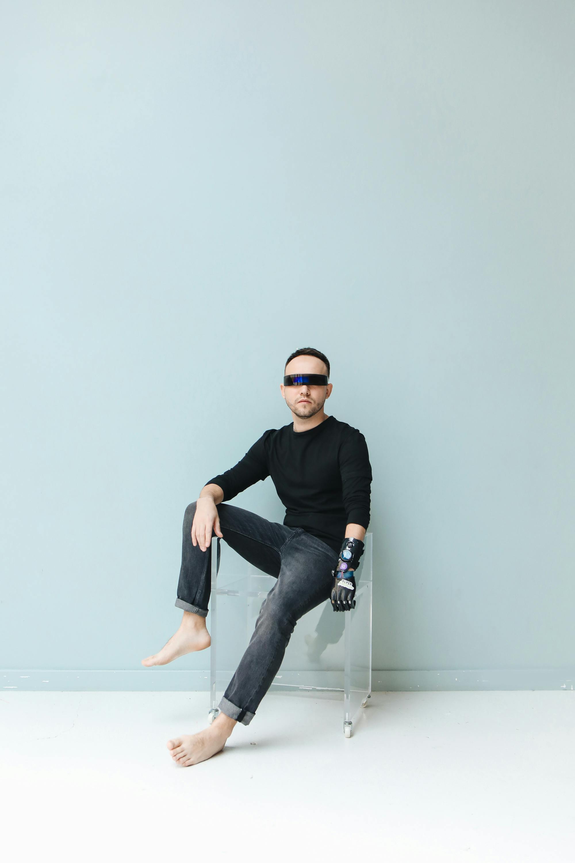 man in blindfold sitting on blue background