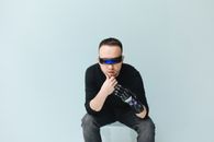 一名男子戴着未来派面罩和假肢，在柔和的背景下摆姿势