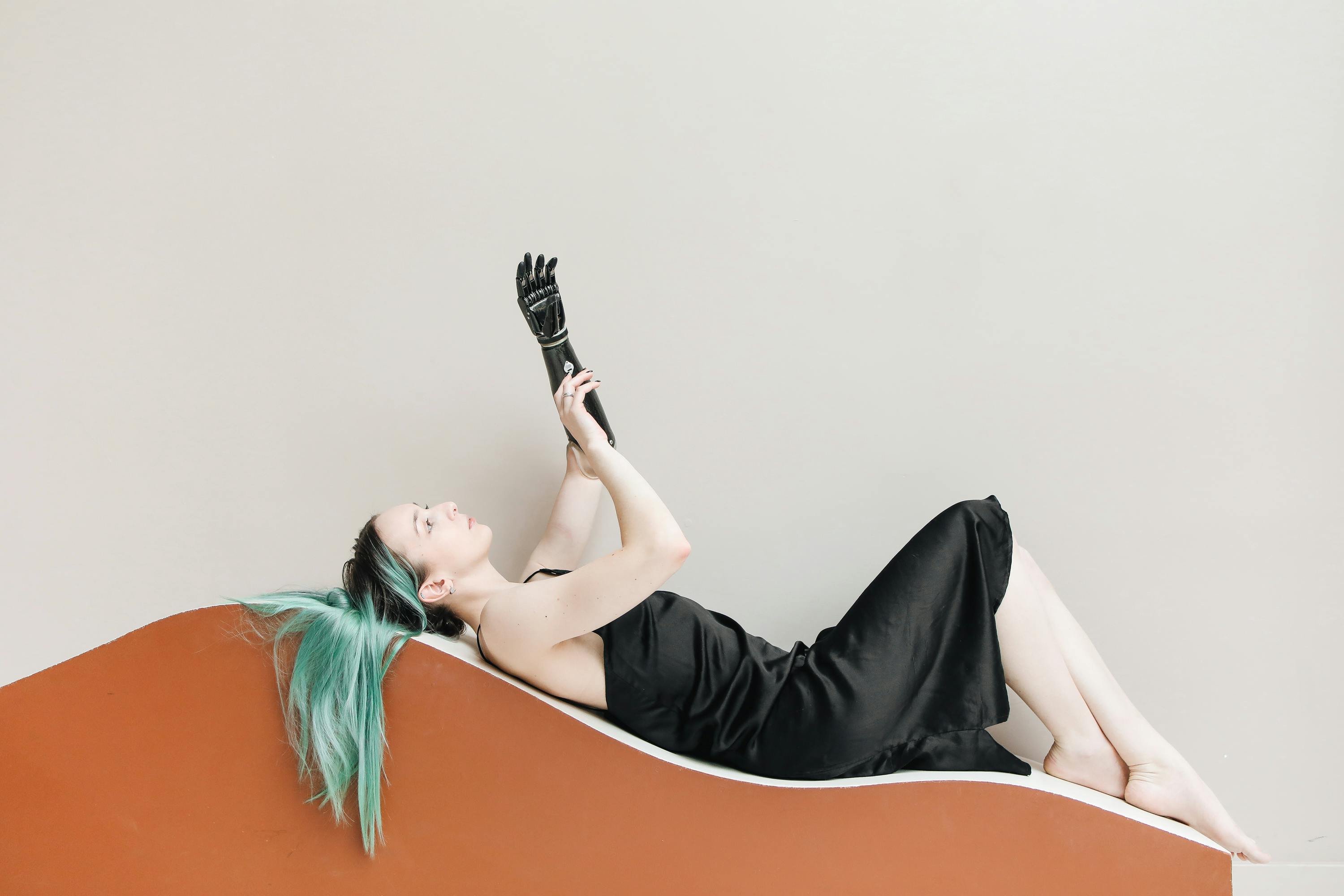 一位戴着假臂的时尚女性身着黑色连衣裙，展现着现代美