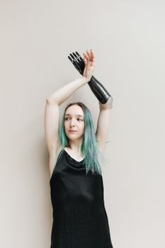 一位自信的女人穿着黑色连衣裙，在工作室里展示她的假肢