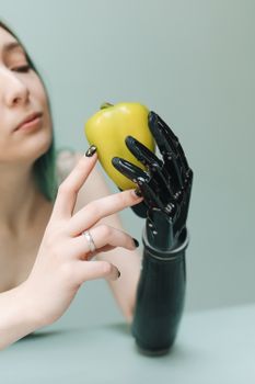 一名戴着黑色假手的妇女正在检查一只绿甜椒