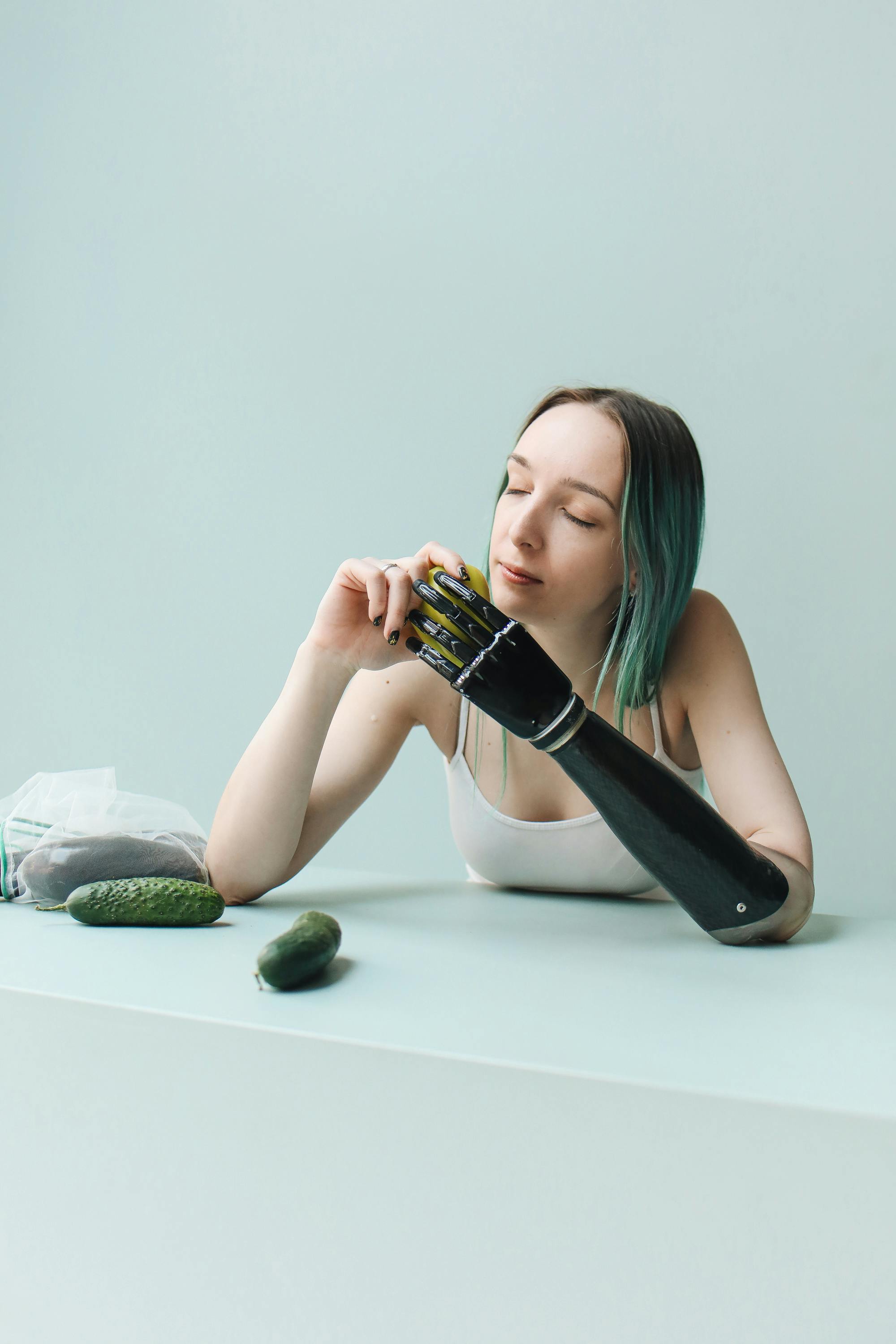 photo of a woman in a white tank top holding a green food