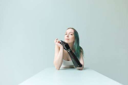 Woman in a Sleeveless Top Posing Near a Mint Wall