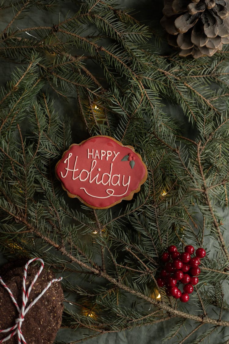 Happy Holiday Title On Christmas Cookie Between Spruce Sprigs