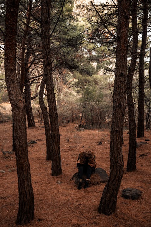 Photograph of a Sad Woman Sitting on a Rock