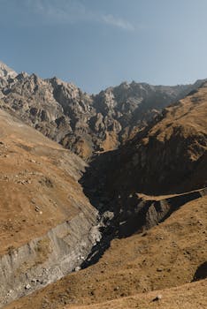 Stunning view of a rugged mountain canyon under a clear blue sky, highlighting nature's grandeur.