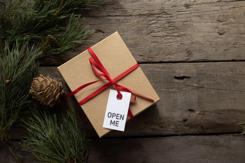 Free From above of organic present box with lace bow and inscription on tag near fir sprigs during New Year holiday Stock Photo
