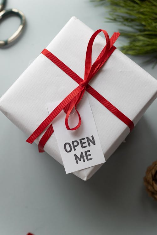 Free Present box with Open Me inscription on tag Stock Photo