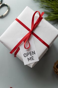 礼品盒的顶视图上装饰着红丝带和“打开我”的标签，为节日庆祝活动增添了完美氛围