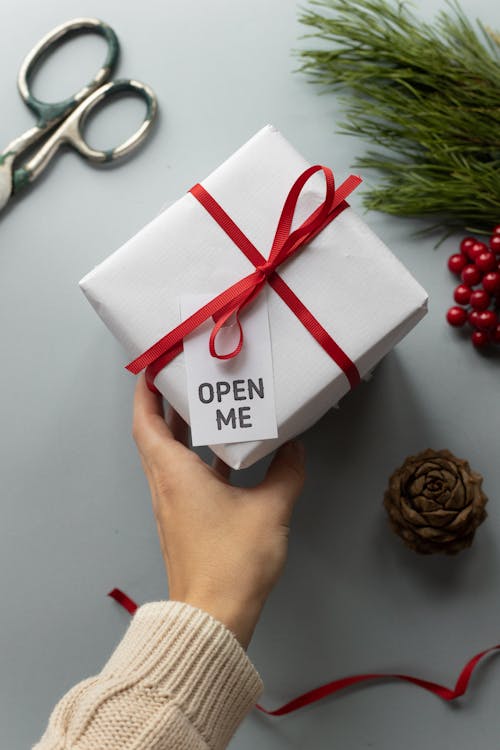 Crop faceless woman holding Christmas gift box