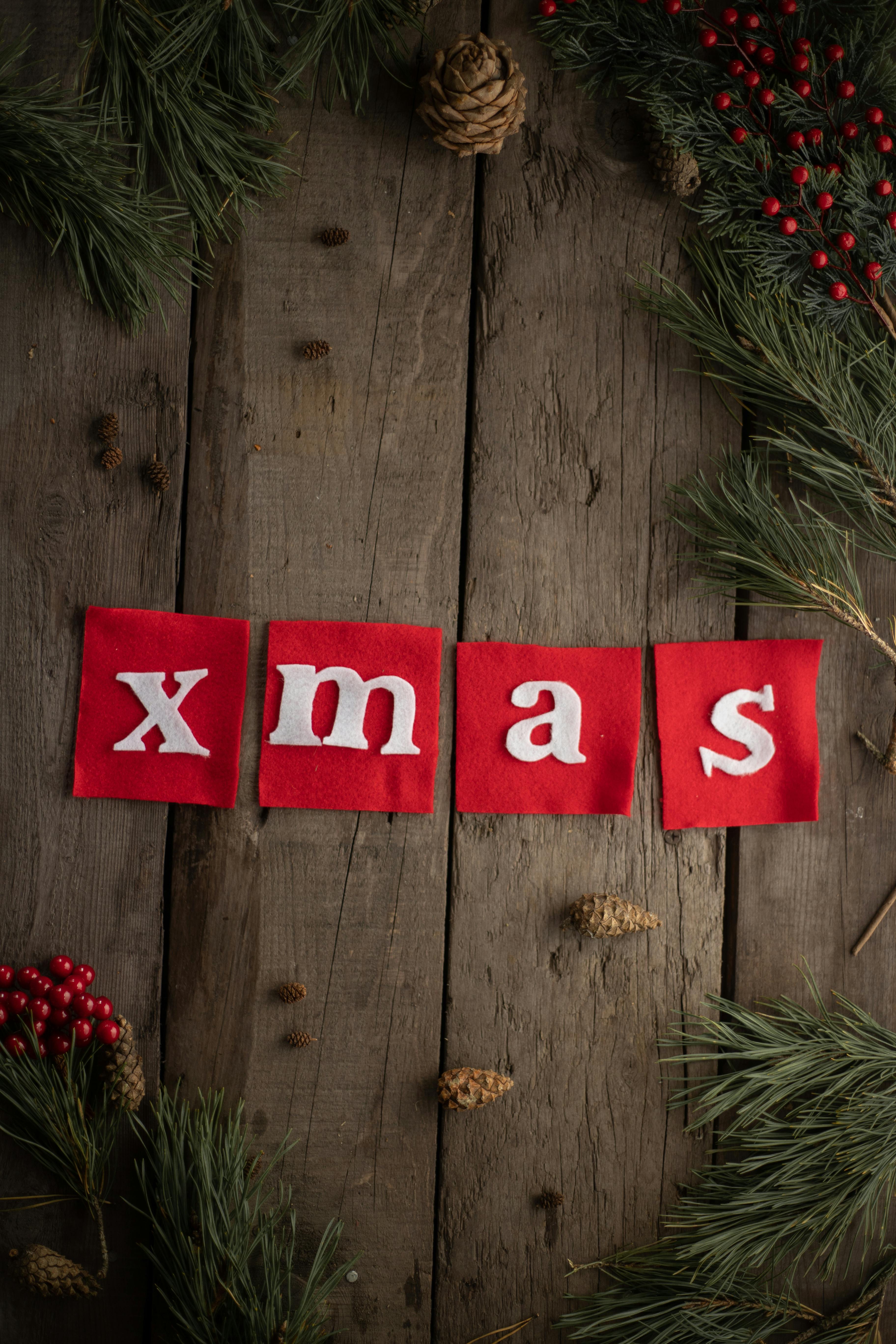 xmas inscription on wooden background with spruce branches