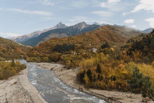 Free Breathtaking autumn landscape featuring a river winding through mountain ranges with colorful foliage. Stock Photo