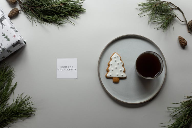 Composition Of Coffee And Cookie On Table With Greeting Card And Coniferous Branches