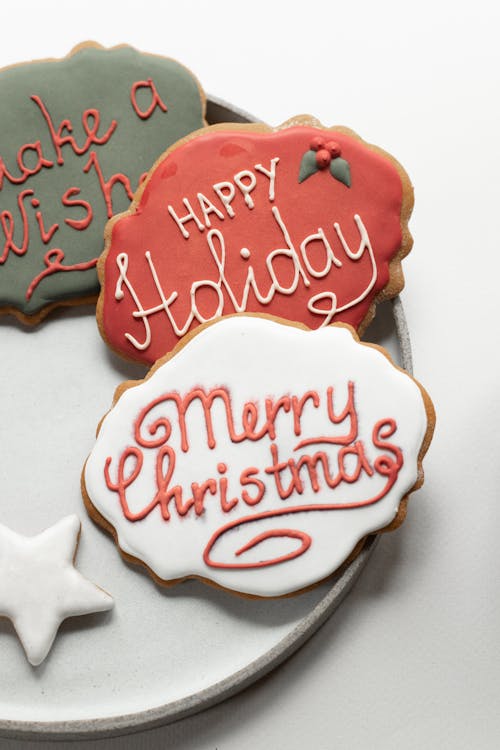Delicious sweet holiday cookies decorated with colorful icing placed on ceramic plate