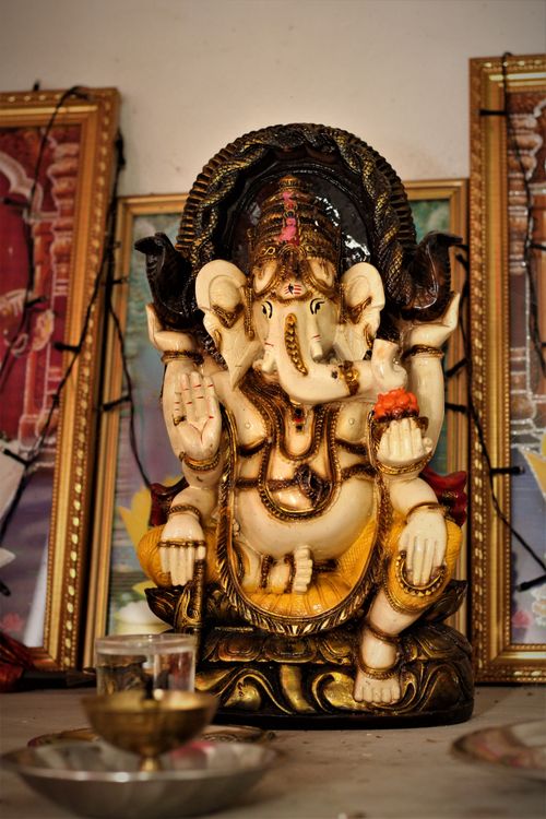Free Close-up of a Ganesha statue surrounded by ornate frames, showcasing Hindu religious art. Stock Photo