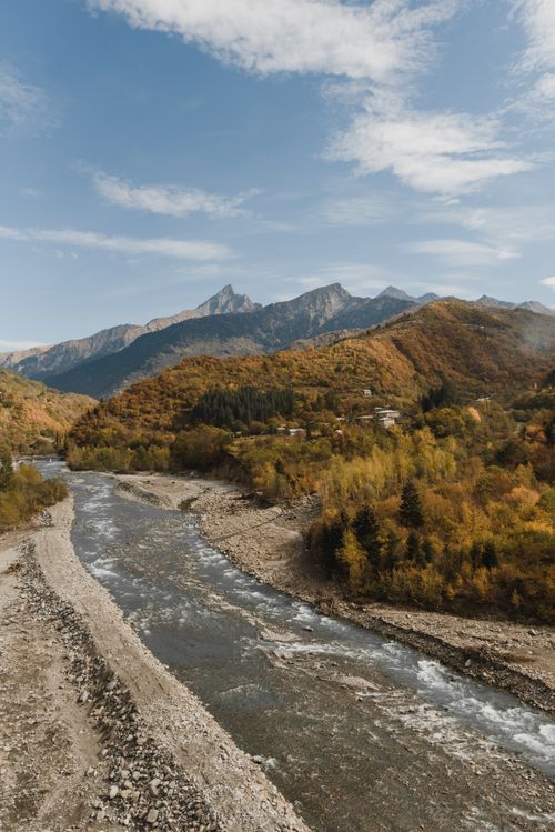 Free A peaceful river flowing through a mountainous autumn landscape. Stock Photo