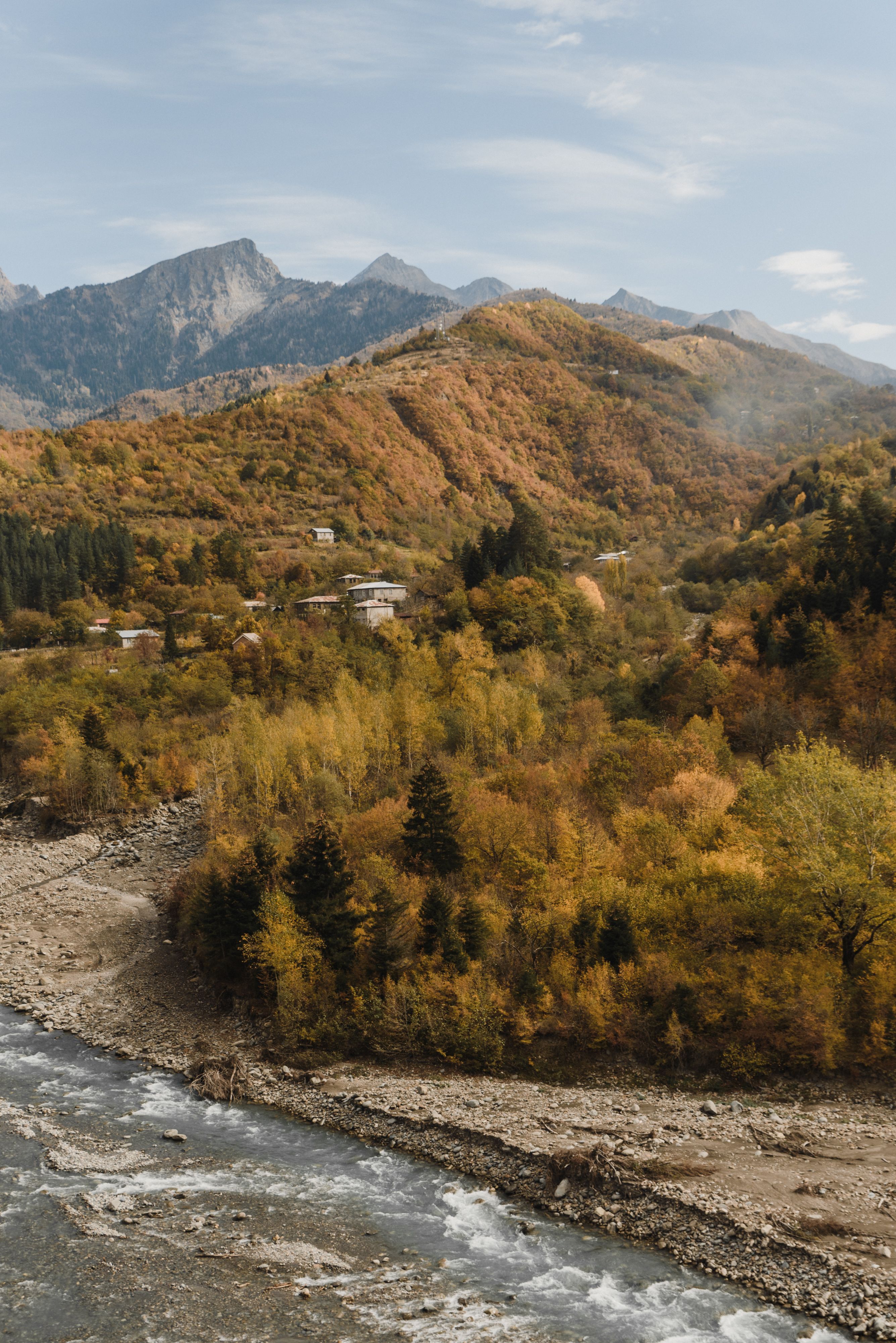 俯瞰充满活力的秋日山景，可见山脉起伏，溪流潺潺