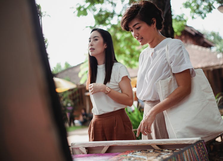 Content Asian Women Choosing Goods In Souvenir Shop In Market