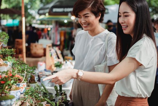 两名妇女喜欢在绿植环绕、色彩鲜艳的户外市场购买植物