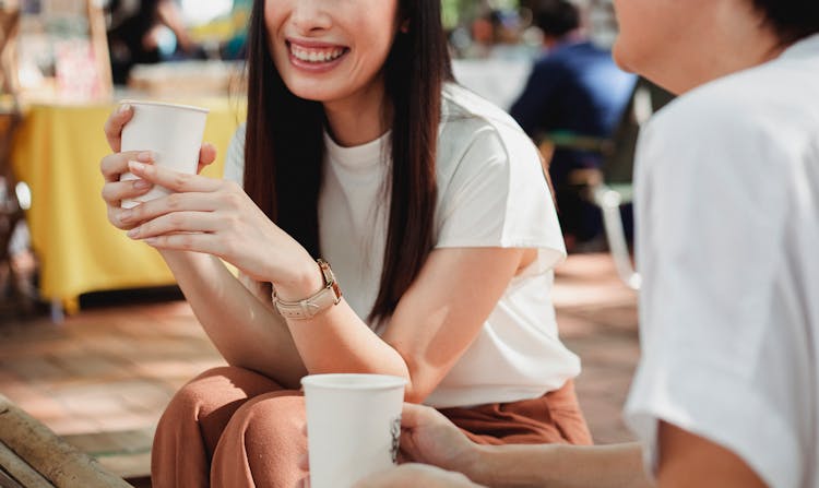 Crop Joyful Women Drinking Coffee On Sunny Street