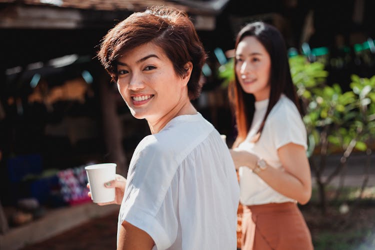 Cheerful Ethnic Woman Enjoying Coffee With Friend